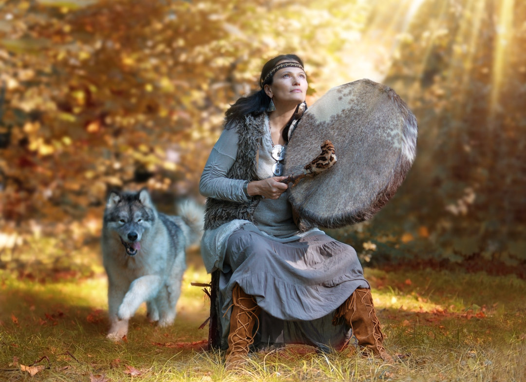Femme jouant du Tambour chamanique avec son loup pour la Formation